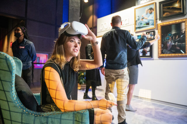 A guest interacts with an AI art installation using a headset at CDT's 2022 Tech Prom.