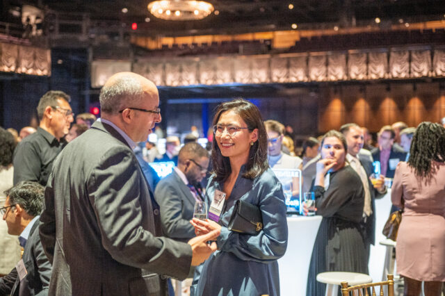 Guests at CDT's 2022 Tech Prom mix and mingle, smiling.