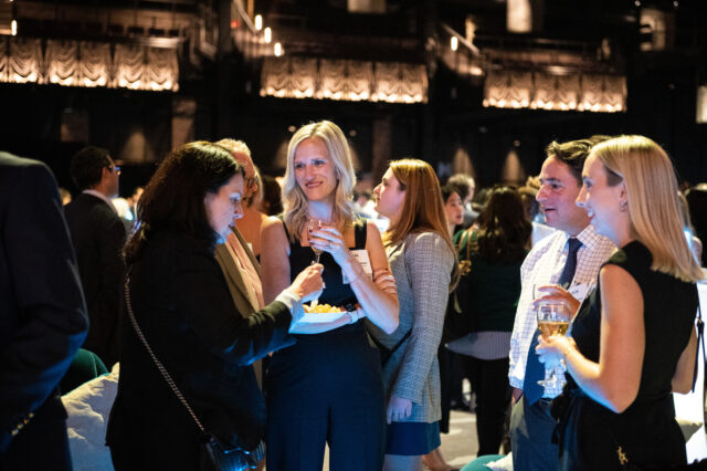 Guests at CDT's 2022 Tech Prom mix and mingle, while eating and drinking.