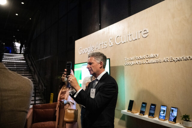 A guest interacts with an AI art installation using a cell phone camera at CDT's 2022 Tech Prom.