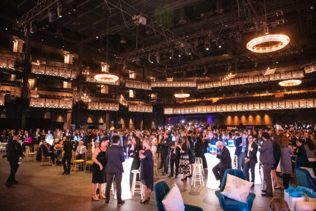 2022 Tech Prom guests fill the Anthem. People chatting across lounges, tables, and chairs.