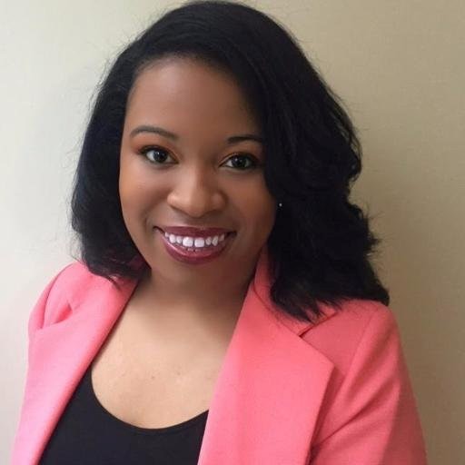 Dr. Alisa Valentin, wearing a black top and pink suit jacket.