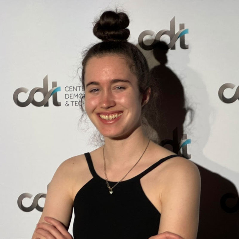 Becca Shields, smiling in a black top in front of a CDT backdrop.