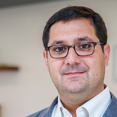Jesse Blumenthal. Director, Technology & Innovation, Apple. Wearing glasses and a white collared shirt with a light blue suit jacket.