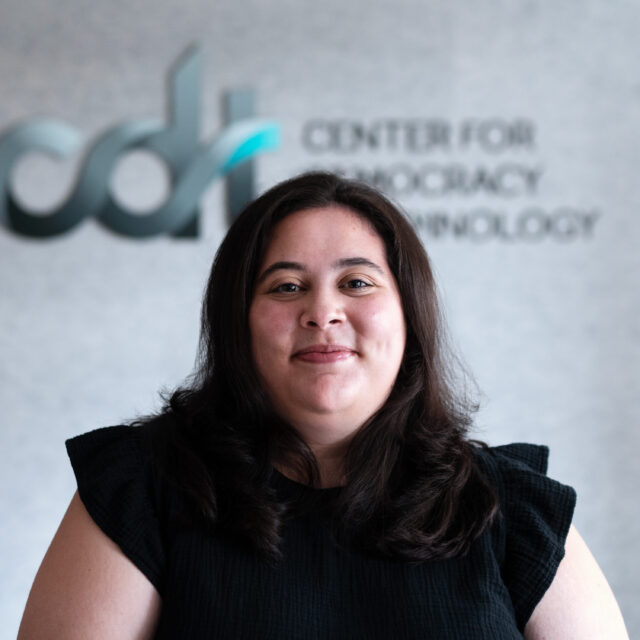 Bella Hillebrand, smiling in a black dress in front of a CDT logo.