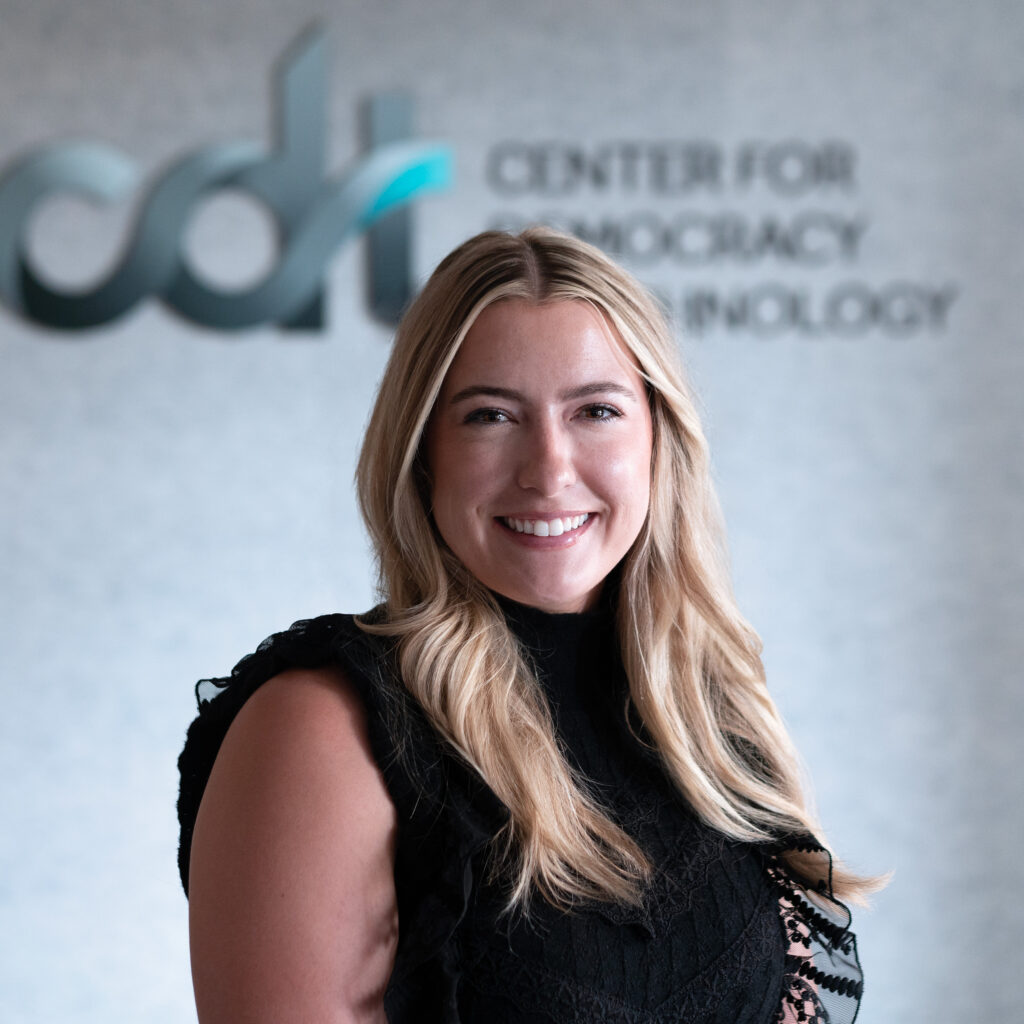 Maddy Dwyer, in a black top smiling in front of a CDT logo.