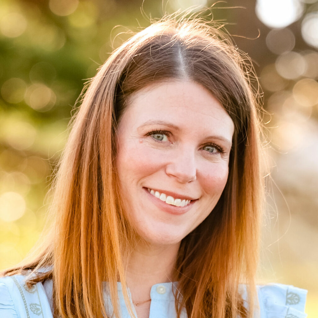Jennifer Hodges, smiling in the sun outdoors while wearing a blue top.