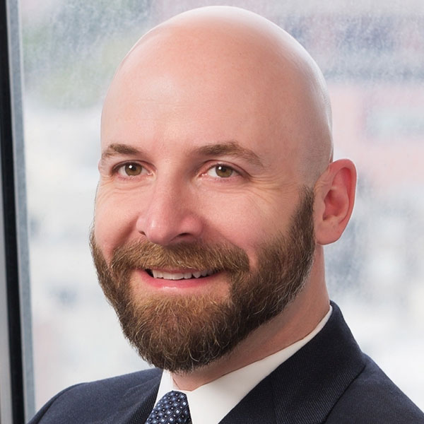 Michael Rubin, smiling in front of a daylight window.