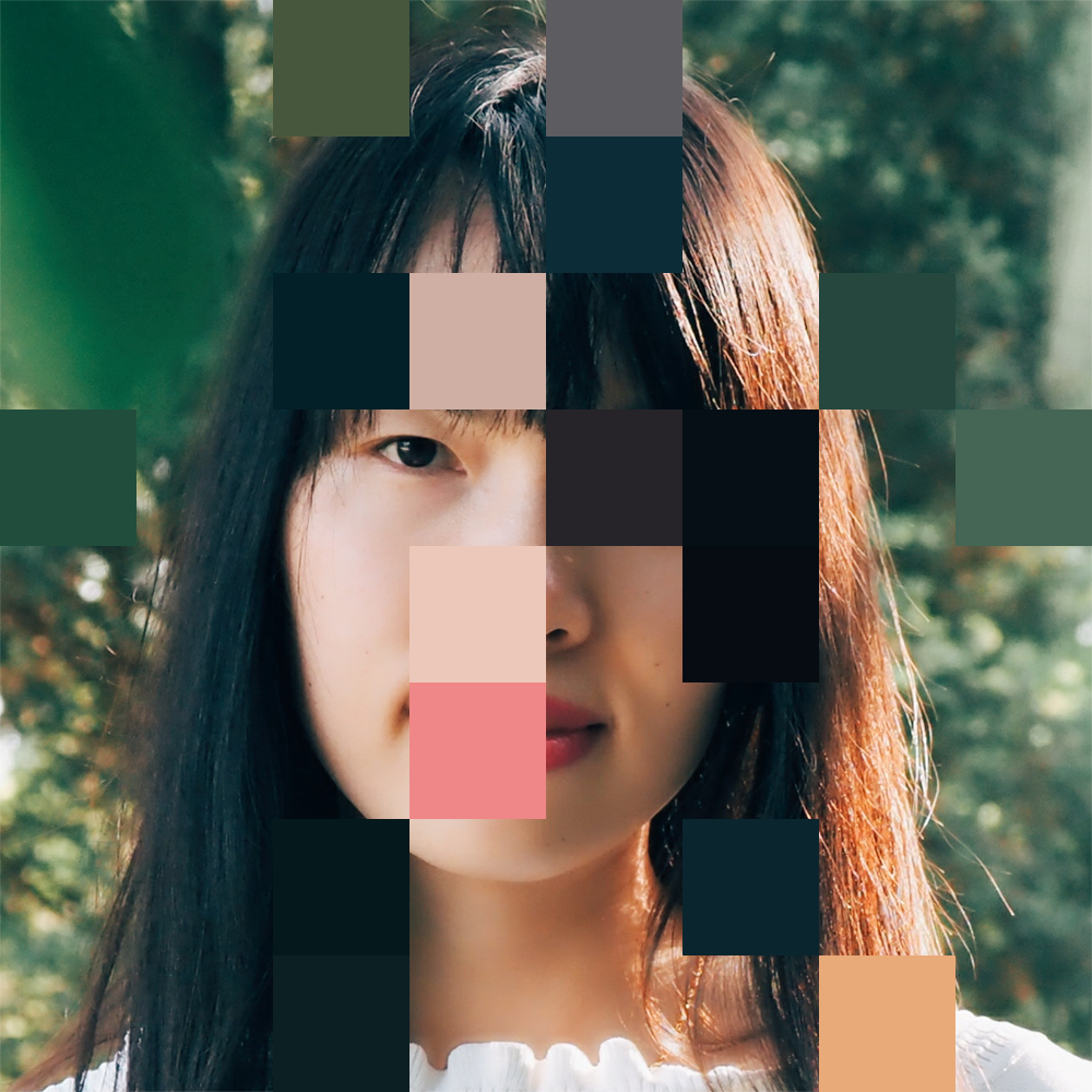 A person's face in a lush green outdoor background, pixelated.