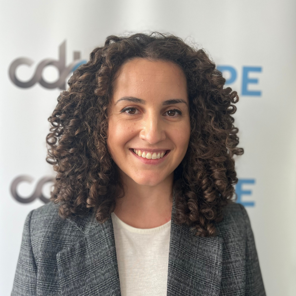 Silvia Lorenzo Perez, smiling in a white top and grey blazer, in front of a CDT Europe backdrop.